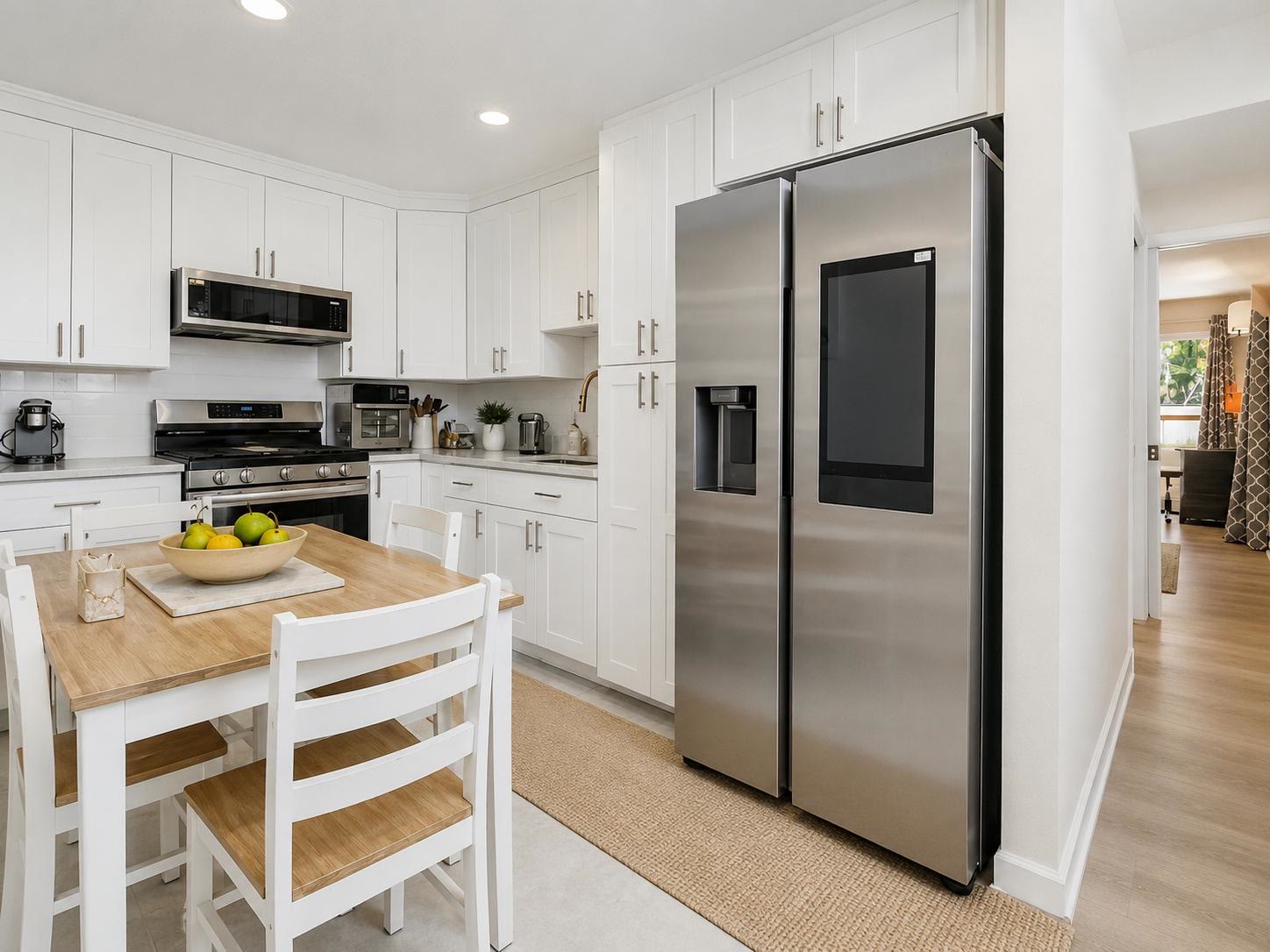 Full white kitchen at Casa Amaris with dining table, range, and stainless appliances